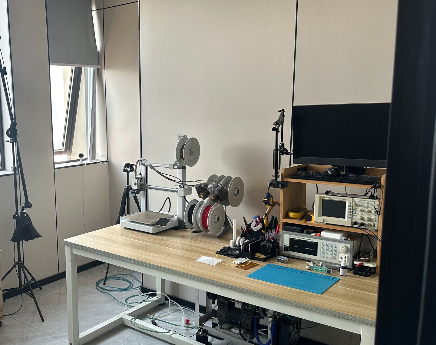Product workbench with a small 3D printer, instruments and photography equipment